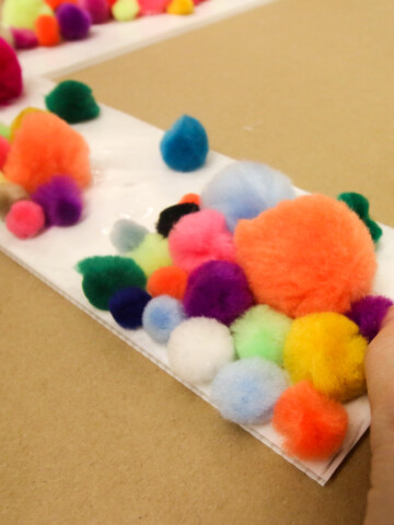 applying pom poms to create large pom pom letters