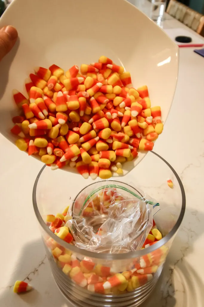 pouring candy corn into a vase