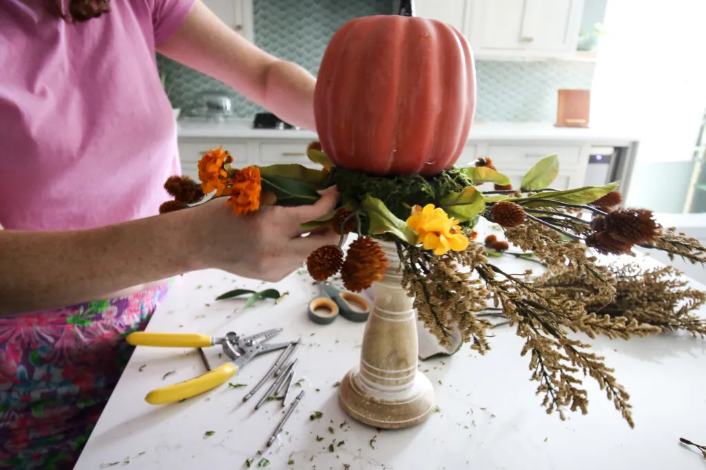 add floral picks to foam pumpkin candlesticks