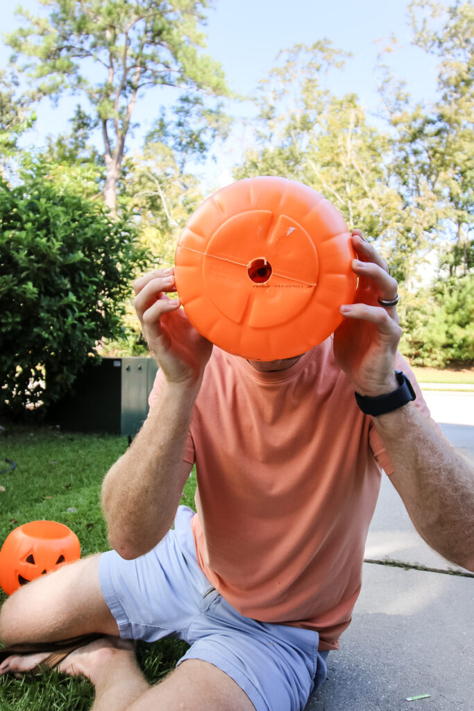 drilling a hole into a plastic pumpkin bucket