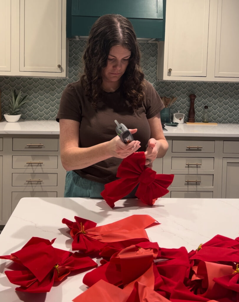 hot gluing bows together to create garland