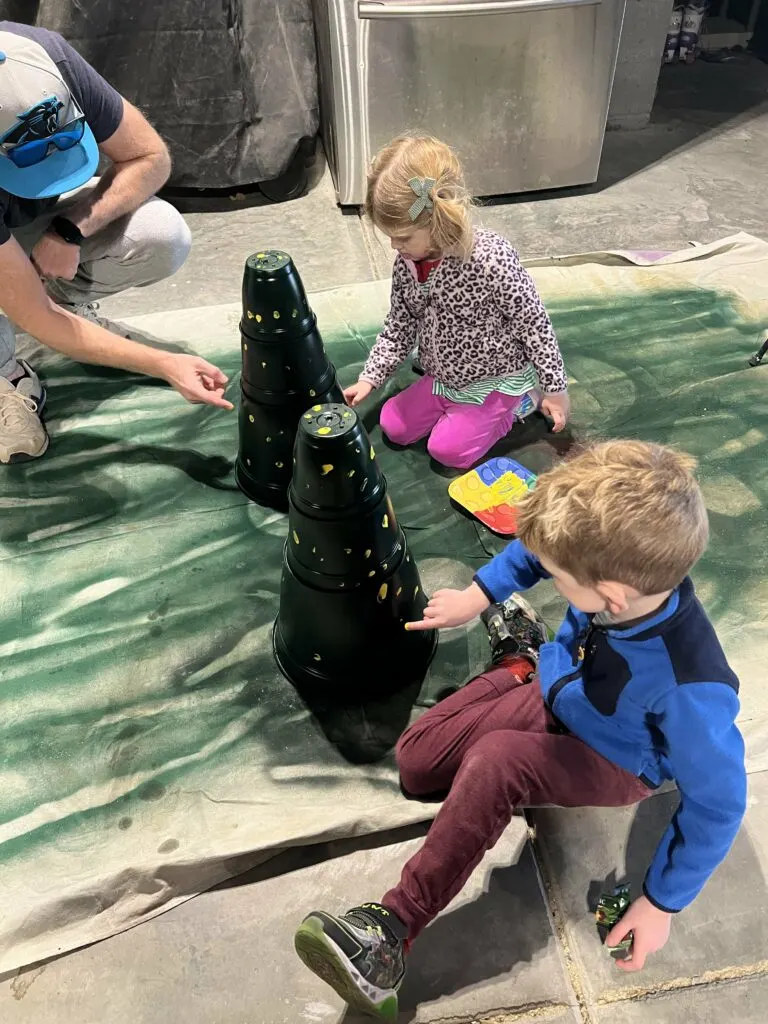 kids painting fingerprints on plastic pot christmas tree