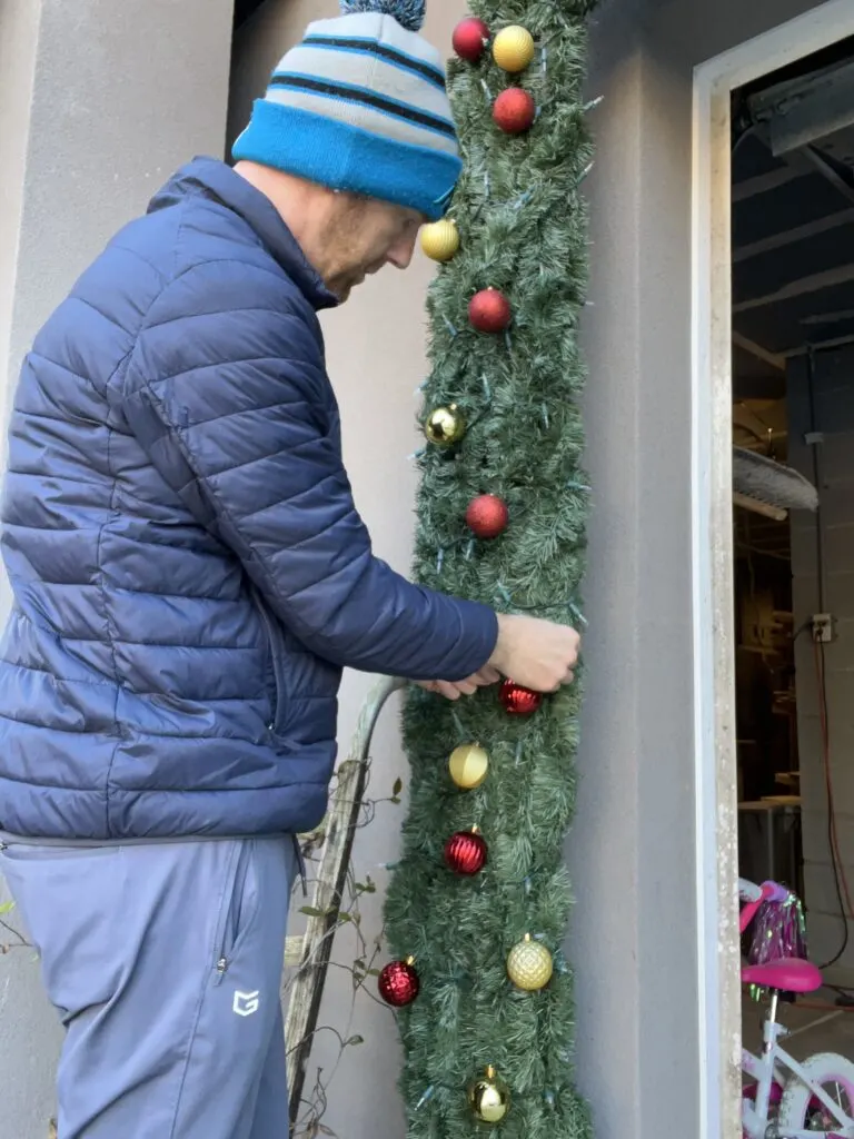 Hanging ornaments on garland arch