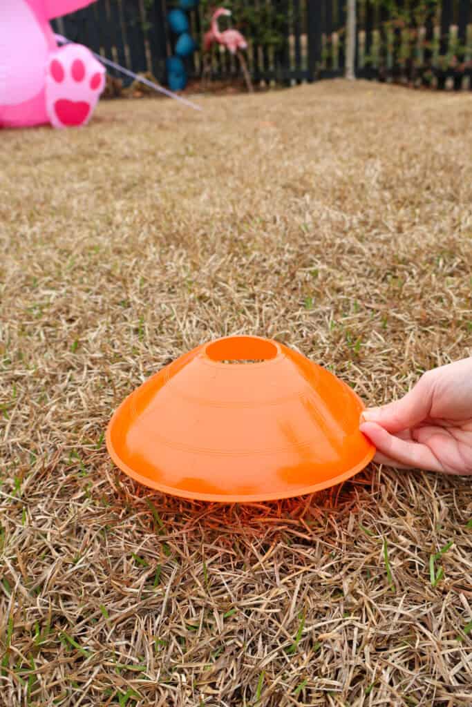 placing orange sports cone in yard