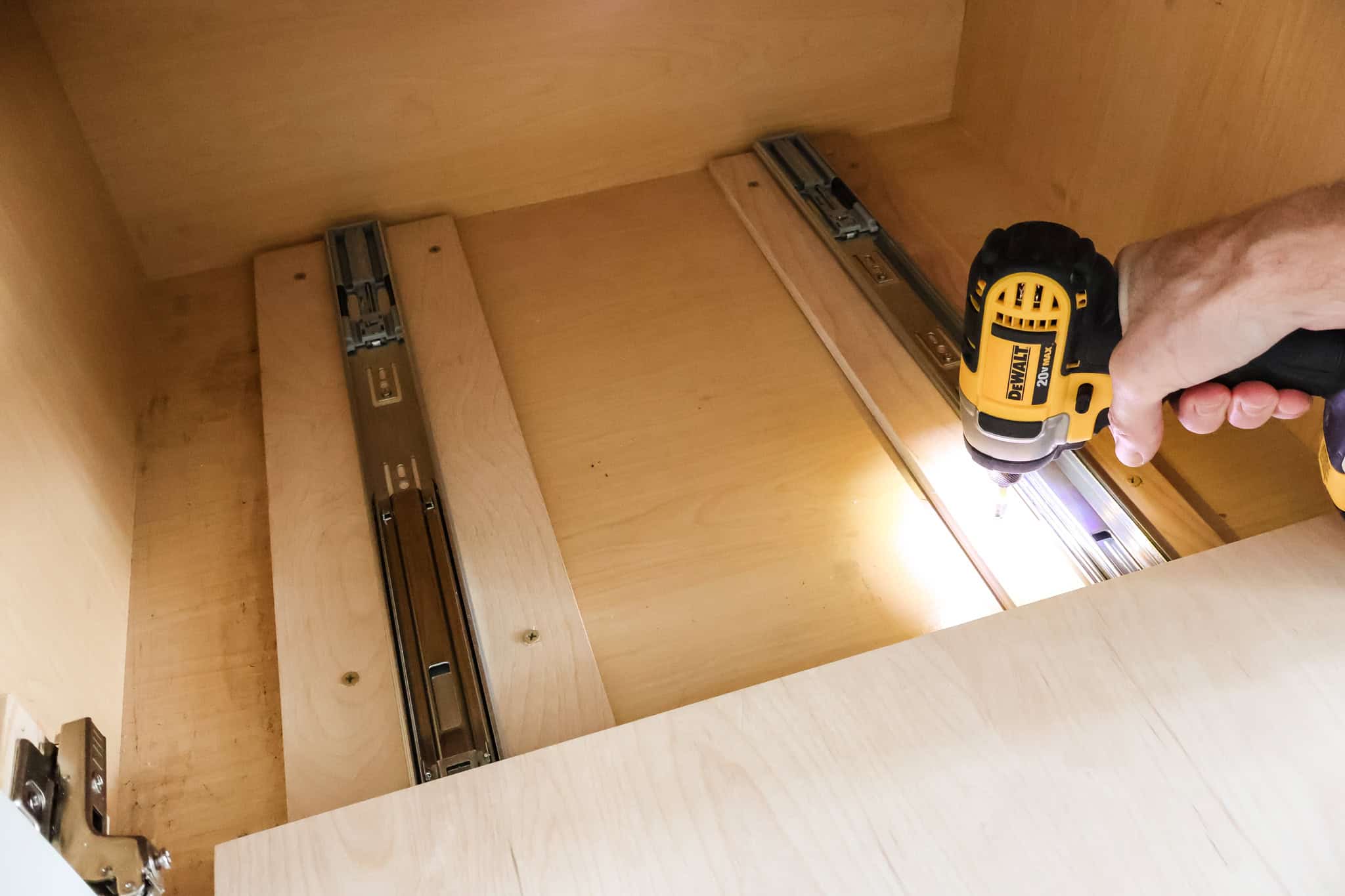 Attaching drawer slide scraps to bottom of cabinet